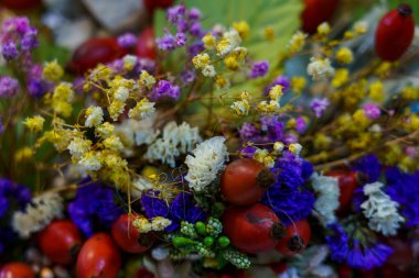 Çeşitli renklerde çiçekler ve kırmızı böğürtlenler birlikte düzenlenir, bir markette doğanın güzelliğini gösterir..