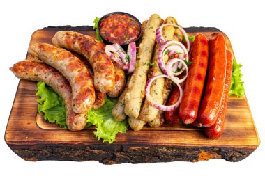 Izgara sosisler ahşap bir tahtada düzenlenir. Salsa sosu ve dilimlenmiş soğan yakınlarda oturur. Yeşil marul sahneye renk katar.