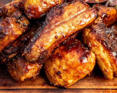 İnsanlar dışarıda toplanan yaz aylarında ahşap bir tahtanın üzerinde ızgara soslu tavuk kanadı yemekten hoşlanırlar..