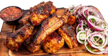 Lezzetli ızgara et ahşap bir tabağa istiflenir ve yemek sırasında yanında taze salata ve sos olur..