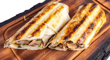 Ahşap bir tahtaya iki ızgara et sargısı konur. Paketlerde ızgara izleri ve susam tohumları var..