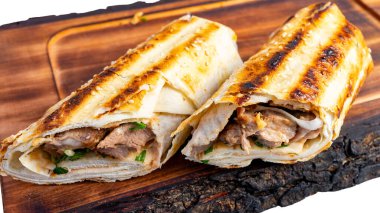 Izgara et ve taze otlarla dolu iki paket yemek için mutfak ortamında ahşap bir tahtanın üzerinde dinleniyor..