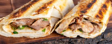 Izgara et ve otlarla dolu iki paket öğle yemeği sırasında bir sokak yemekhanesinde ahşap bir masada servis edilir..