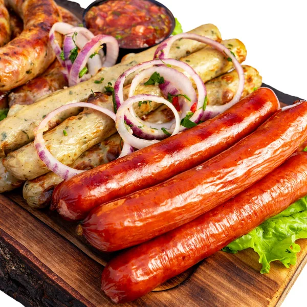 Sosisler ahşap bir tahtada düzenlenir. Yakınlarda soğan ve bir kase sos var. Aydınlık ve davetkar bir ortam..