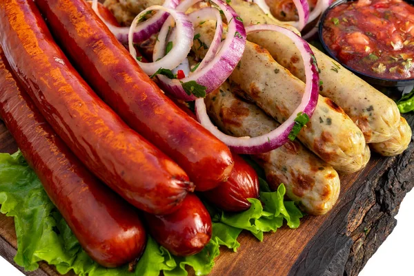 Ahşap bir tahtada çeşitli sosisler soğan, marul ve sos ile düzenlenir. Sahne, paylaşmak için basit bir yemek düzenini gösteriyor..