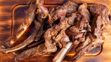 Kuzu kaburgaları pişirilir ve ahşap bir tahtada hazırlanır.