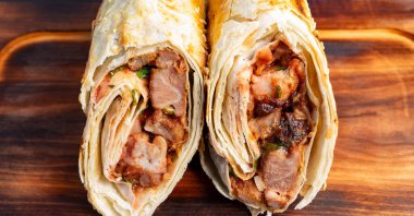 İçerideki et ve sebzeleri gösteren bir paket ikiye bölündü. Tahtaya konur ve yemeye hazırdır..