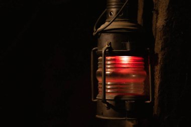 Madenin girişinde siyah arka planda parlak turuncu bir fener var.