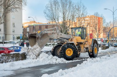 Fuenlabrada, Madrid, İspanya; 01-10-2021: Kazıcı fırtınadan sonra yoldaki büyük miktarda karı kaldırdı 