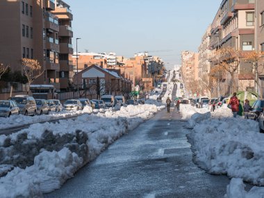 San Sebastian de los Reyes, Madrid, İspanya; 01-13-2021: Filomena fırtınasının şehir sokaklarındaki geçişi sonrasında araçların taşınması için karlar arasında yollar açıldı