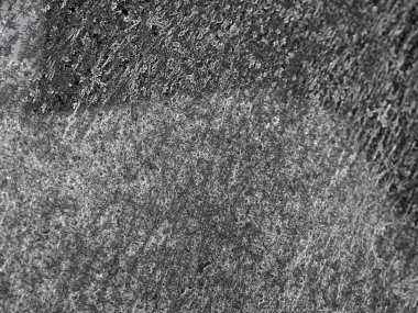 Tamamen donmuş metalik siyah bir arabanın kaputu ürkütücü ve kasvetli bir arka plan oluşturuyor.