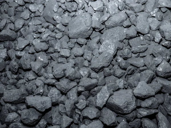 A large pile of carbon stones piled up for subsequent combustion, forming an energetic background of this precious mineral used in homes for combustion and producing heat energy to heat the home
