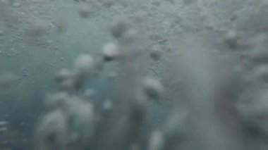 4K 'de bir deniz suyu dalgasının ağır çekimde çekilmiş videosu. Sahilde kırılıp, güneşli bir yaz günü muhteşem bir baloncuk arka planı oluşturuyorlar.