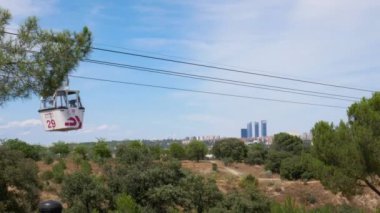 Madrid, İspanya; 06-27-2021: Madrid tramvayı arka planda Cuatro Torres İş Alanı olan kır evinin tepesine doğru ilerliyor.