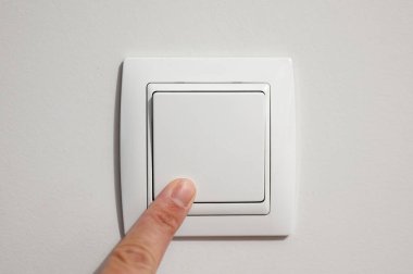 Güç tüketiminin görüntüleri, bir adamın parmağının düğmeyi açıp kapatması.