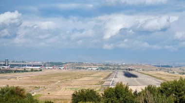 Madrid, İspanya; 09-25-2021: Madrid Barajas havaalanı pisti ve terminali, İberya Ekspres Havayolu 'nun bir Airbus A321' inin bulutlu bir gökyüzü ile havalandığını görebiliyoruz.