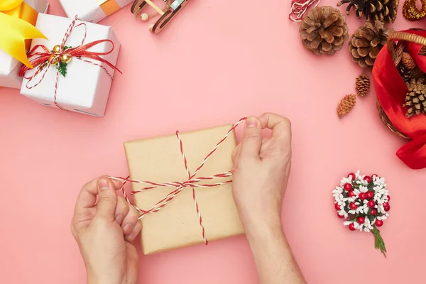 Buon regalo di Natale che avvolge passo dopo passo, decorazioni su sfondo rosa, spazio copia — Foto Stock