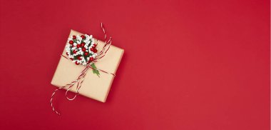 Mutlu Noeller kartpostal afişi, kırmızı arkaplanda süslemeler