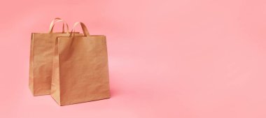 Pembe zemin üzerinde iki kağıt el işi paketi, afiş, kopyalama alanı, maket