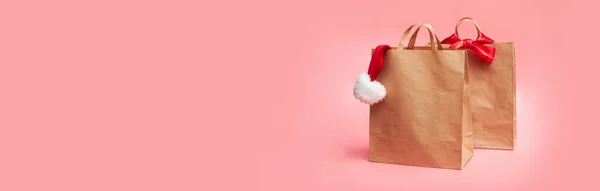 Concetto Natale Due Sacchetti Carta Con Cappello Natale Sfondo Rosa — Foto Stock