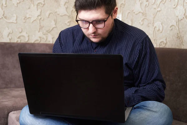 Běloch s brýlemi sedící u laptopu, kopírovací prostor — Stock fotografie