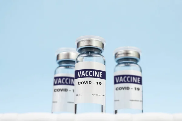 Tři plechovky koronavirové vakcíny. na modrém pozadí. kopírovat mezeru, nápis Stock Obrázky