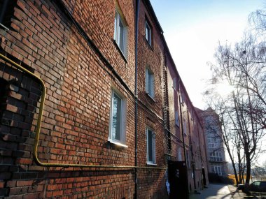 Güneşli bir günde Rusya 'nın Kalininingrad kentinde (eski adıyla Koenigsberg) tarihi kent merkezinde kırmızı tuğlalı duvarları olan eski konut binasının cephesi