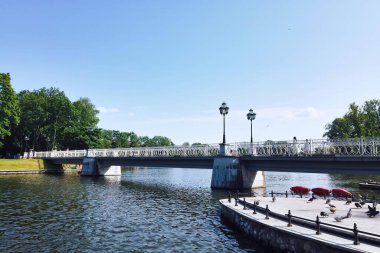 Yukarı Göl 'ün rıhtımındaki yaya köprüsü - yapay şehir havuzu, ünlü turistik manzara ve güneşli yaz gününde Rusya' nın Kalininingrad kentinde popüler dinlenme bölgesi