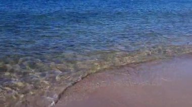 Sakin, berrak turkuaz su dalgaları güneşli yaz gününde Baltık kıyılarında kumların sığ kumsallarında akıyor. Huzurlu bir deniz manzarası olmadan, doğal arka plan..