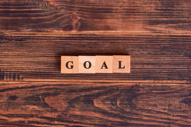 Koyu ahşap arka planda yapı taşlarıyla yapılmış bir hedef kelime. İş hedefi kavramı