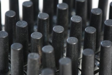 Siyah plastik silindirlerin soyut arkaplanı. Enjeksiyon kalıbı plastik fabrikası ve endüstri konsepti