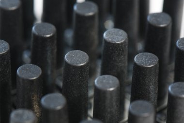 Siyah plastik silindirlerin soyut arka planı, kauçuk ürün. Enjeksiyon kalıbı plastik fabrikası ve endüstri konsepti