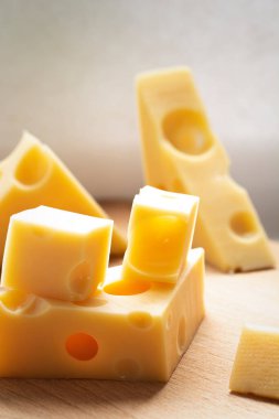 Taze sarı peynir parçaları, ahşap masanın üzerinde. Süt ürünü konsepti.
