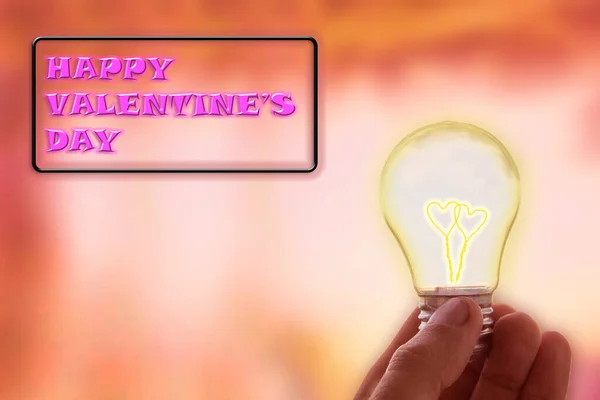 Man hold light bulb in hand, inside which there are two hearts against the sky and the sun. Innovation, brainstorming, solution concepts, the concept of pure energy, love and unity with nature. New idea