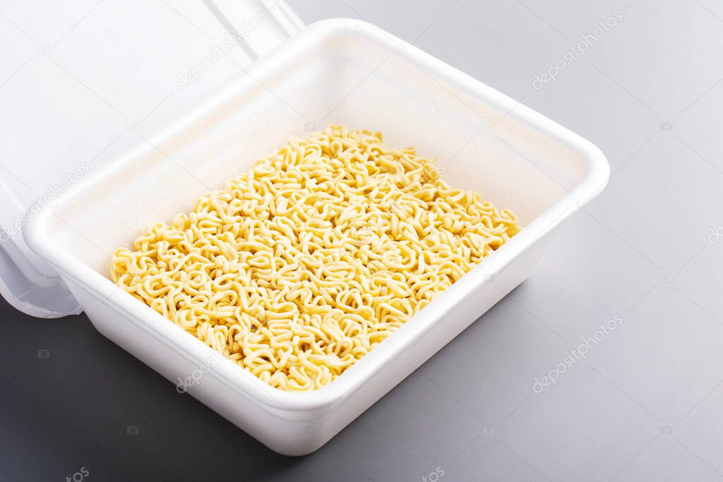 Instant Chinese noodle on grey background. Asian Fast food, junk food, unhealthy food. Rolton or Doshirak