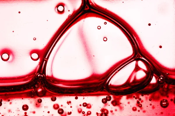 Red liquid soap bubbles. Oil on surface of water Soap foam. Abstract macro view of blood molecule sctructure. Shallow depth of field image