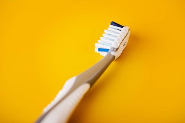 Diş fırçası, sarı arka planda izole edilmiş. Diş sağlığı konsepti.