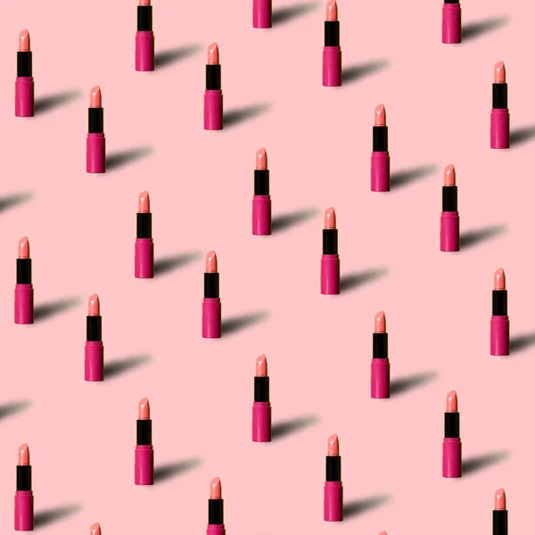 Red lipstick on pink colored background in pop art style. Minimal makeup cosmetic pattern