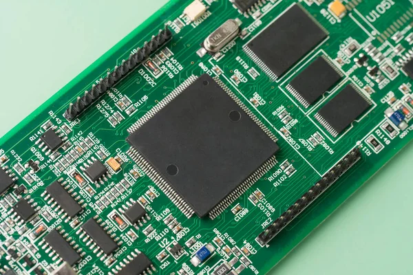 Electronic chip component. Printed circuit boards PCB on green background. Minimal industry backdrop