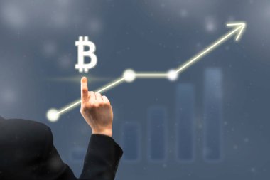 İşadamı dijital bitcoin ikonunu işaret ediyor. Çizelge ve diyagram, artan bitcoin fiyatlarının grafiği. Sanal kripto para birimi borsa konsepti