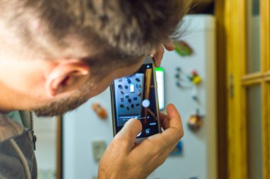 Cep telefonu kamerası olan beyaz bir adam.