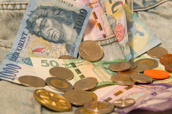 Farklı ülkelerden kot pantolon için banknotlar ve madeni paralar: Polonya zlotileri, Macaristan forinti, Fas dirhemi, Çek tacı, avro ...