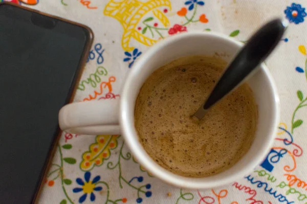 İş saatinde cep telefonu ve dizüstü bilgisayarla Espresso.