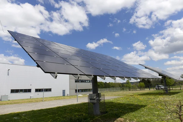 Detalhe da Central de Energia Solar no prado florido primavera no dia ensolarado — Fotografia de Stock