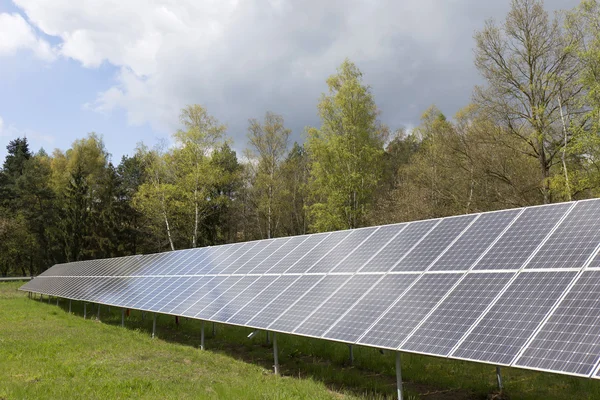 晴れた日に草原を開花春の太陽光発電所の詳細 — ストック写真