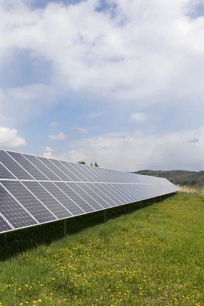 Detalhe da Central de Energia Solar no prado florido primavera no dia ensolarado — Fotografia de Stock