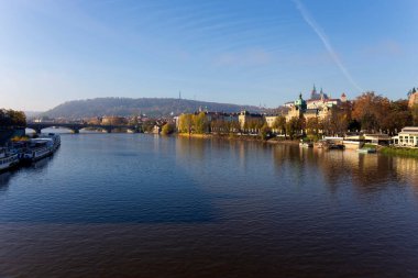 Çek Cumhuriyeti 'nin güneşli bir gününde Vltava Nehri üzerindeki Gotik Şatosu ile Sonbahar Renkli Prag Küçük Kasabası
