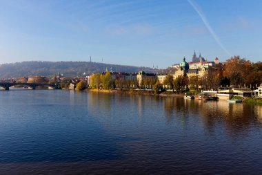 Çek Cumhuriyeti 'nin güneşli bir gününde Vltava Nehri üzerindeki Gotik Şatosu ile Sonbahar Renkli Prag Küçük Kasabası