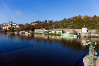 Çek Cumhuriyeti 'nin güneşli bir gününde Vltava Nehri üzerindeki Gotik Şatosu ile Sonbahar Renkli Prag Küçük Kasabası