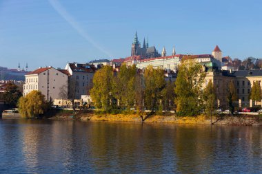 Çek Cumhuriyeti 'nin güneşli bir gününde Vltava Nehri üzerindeki Gotik Şatosu ile Sonbahar Renkli Prag Küçük Kasabası